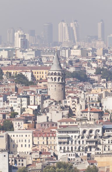 Die Galatabrücke erhebt sich über einer Stadtansicht mit modernen Hochhäusern im Hintergrund.