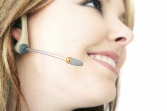 Frau mit Headset lächelt, bereit zur Kommunikation.